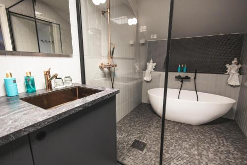 a bathroom with a tub and a sink and a bath tub at The Folks Hotel Konepaja in Helsinki
