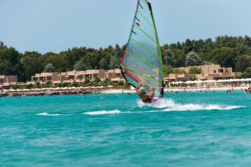 a person windsurfing in the water near a beach at Porto Sani in Sani Beach