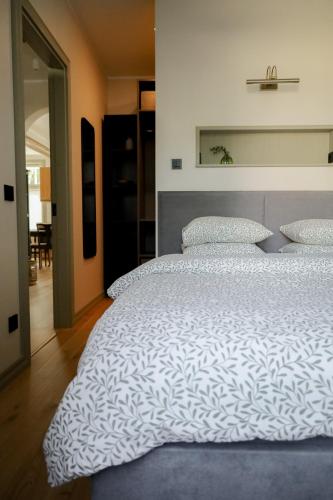 a bedroom with a large bed with white sheets and pillows at Vaksali Apartment, vaid kahe minuti kaugusel Ugala teatrist in Viljandi