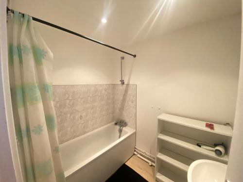 une salle de bain avec une baignoire et un lavabo dans l'établissement Au dessus du jardin - 185, à Sotteville-lès-Rouen