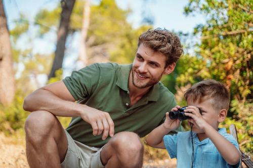 a man taking a picture of a little boy with a camera at Sani Beach in Sani Beach