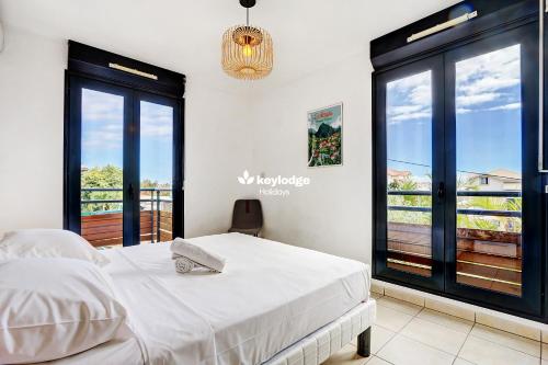 ein Schlafzimmer mit einem Bett und einem Balkon in der Unterkunft Leu Ty Kosy - T3 en plein centre-ville - Saint-Leu in Saint-Leu