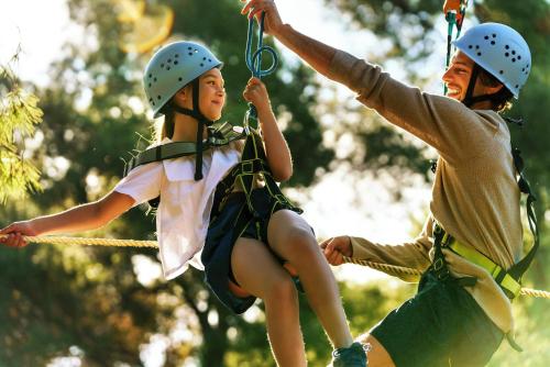 a man and a young girl on a zip line at Porto Sani in Sani Beach