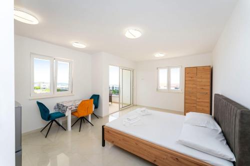 a bedroom with a bed and a table and chairs at Sea View Apartments Ryta in Novalja