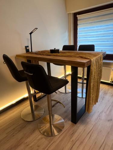 a wooden table with chairs and a lamp on top at Budahome im Schwarzwald in Neuenbürg