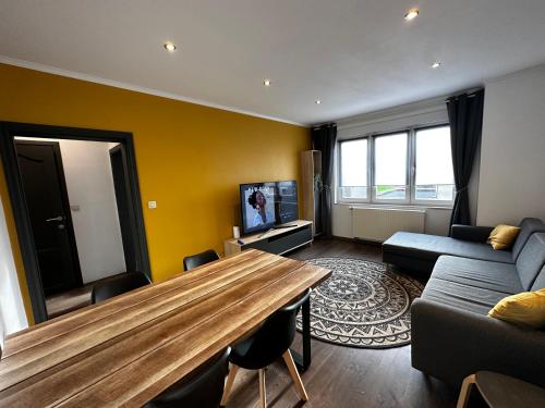 a living room with a wooden table and a couch at LFA - 11811 - Appartement Cosy près du centre in Loncin