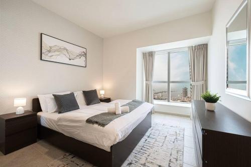 a bedroom with a large bed and a large window at Lux 2BR with Sea Views in Marina in Dubai