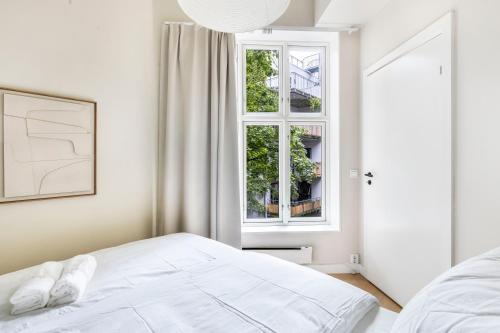 une chambre blanche avec un lit et une fenêtre dans l'établissement Top standard apartment in the heart of Oslo, à Oslo