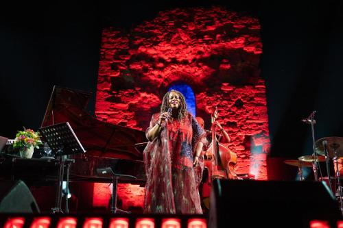 a woman standing on a stage with a microphone at Porto Sani in Sani Beach