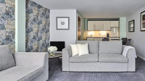 a living room with a couch and a table at Fraser Suites Glasgow in Glasgow