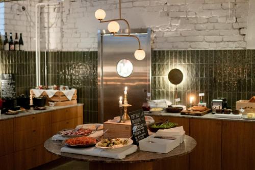a kitchen with a table with food on it at The Folks Hotel Konepaja in Helsinki