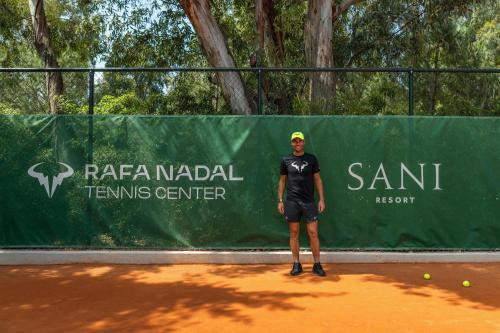 a man is standing on a tennis court at Sani Club in Sani Beach