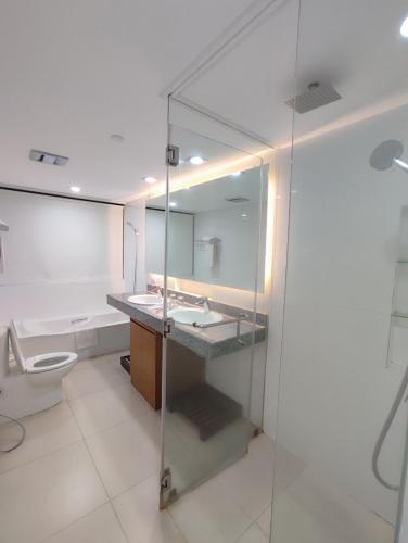 a bathroom with a toilet and a glass shower at PonteFino Hotel in Batangas City