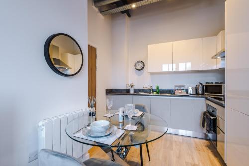 a kitchen with a glass table in a room at Meadow Mill Apartments by Staycay in Heaton Norris
