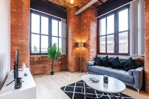 a living room with a couch and a table at Meadow Mill Apartments by Staycay in Heaton Norris