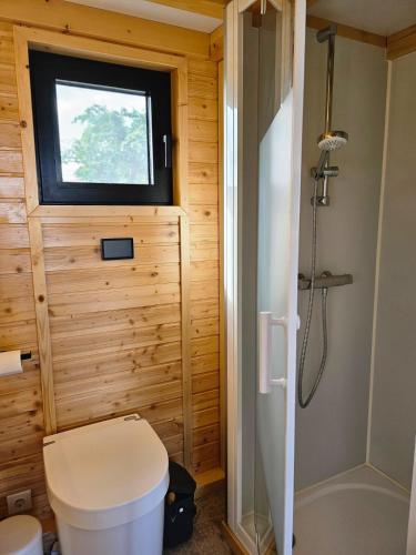 a small bathroom with a toilet and a window at Behagliches OFFGRID Tiny House - Escape to Nature in Sankt Pölten