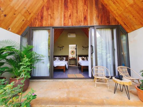 a room with sliding glass doors and a bedroom at Buon'S garden in Buôn Kao
