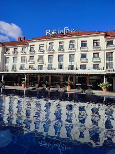 a large building with a reflection in the water at PonteFino Hotel in Batangas City