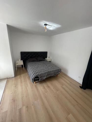 une chambre avec un lit et un parquet dans l'établissement Paris chez jade, à Thiais