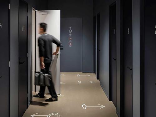a man in a suit walking into a locker room at 9h nine hours Shinagawa station for men in Tokyo