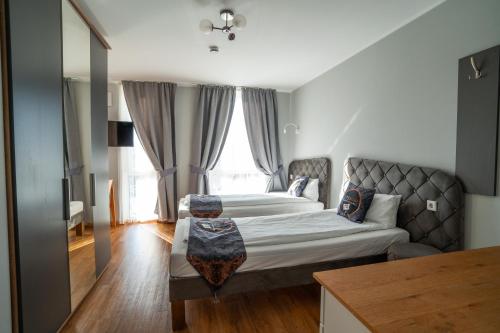 a bedroom with two beds and a large window at Boardinghouse City Home in Bielefeld