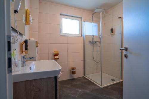 a bathroom with a shower and a sink and a tub at Boardinghouse City Home in Bielefeld