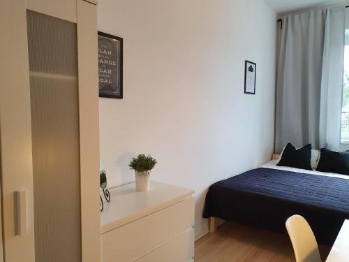 ein Schlafzimmer mit einem Bett, einer Kommode und einem Fenster in der Unterkunft Mieszkanie w centrum Gdyni SW 135L in Wzgórze Nowotki