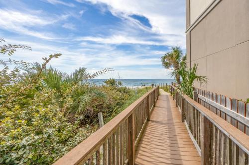 a boardwalk leading to the beach from a building at Grand Caribbean East 207 By Pkrm in Pensacola