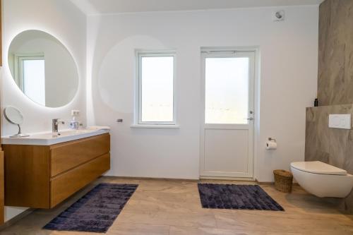 a bathroom with a sink and a toilet and a mirror at Villa in Akureyri with a hot tub and scenic view in Akureyri
