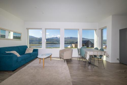 a living room with a blue couch and a table at Villa in Akureyri with a hot tub and scenic view in Akureyri