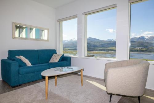 a living room with a blue couch and a table at Villa in Akureyri with a hot tub and scenic view in Akureyri