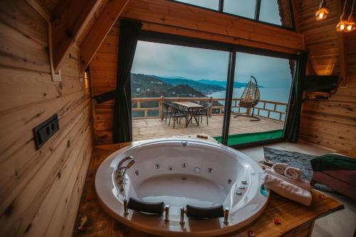 ArdeşenにあるSeyredelim bungalovsのデッキ付きの客室で、大きなバスタブが備わります。
