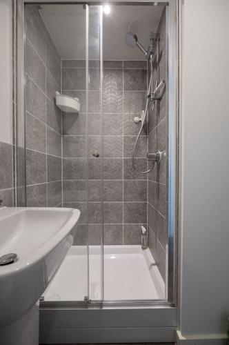 a bathroom with a shower and a sink at Cosy 3 Bed Near Beaches, Cardiff & Brecon Beacons in Coity