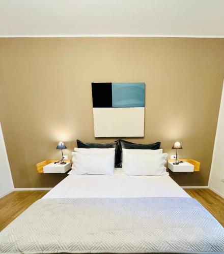 a bedroom with a large white bed with two lamps at Domus Lucia in Syracuse