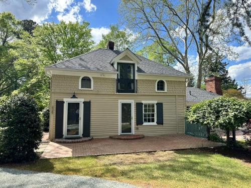 a yellow house with a porch and a yard at Newly Renovated Carriage House in Hillsborough