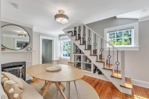 a living room with a staircase and a table at Newly Renovated Carriage House in Hillsborough