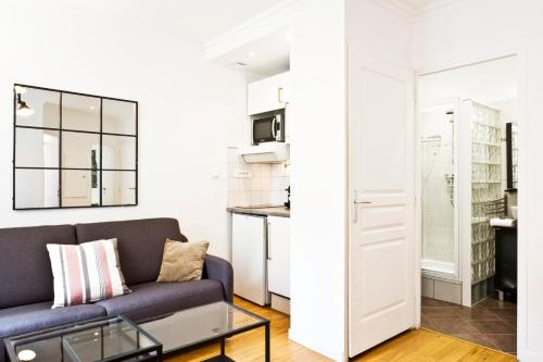 un salon avec un canapé et un miroir dans l'établissement Bluestay 275 - Charmant Appartement à Paris, à Paris