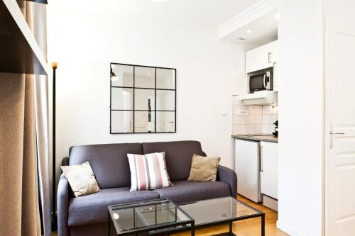 un salon avec un canapé et une table dans l'établissement Bluestay 275 - Charmant Appartement à Paris, à Paris