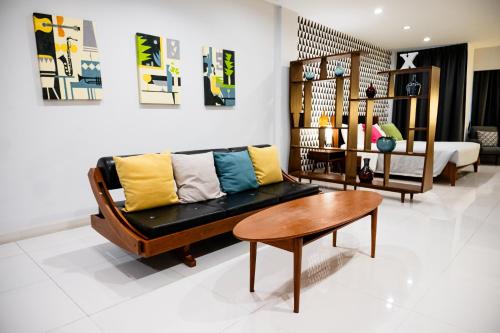 a living room with a couch and a table at Tolani Nimman Villa Chiang Mai in Chiang Mai