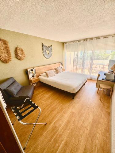 a bedroom with a bed and a chair and a desk at CAPAO Beach Hôtel in Cap d'Agde