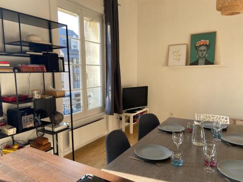 une salle à manger avec une table et une télévision dans l'établissement Idéalement placé, proche gare et plage du Sillon, à Saint-Malo