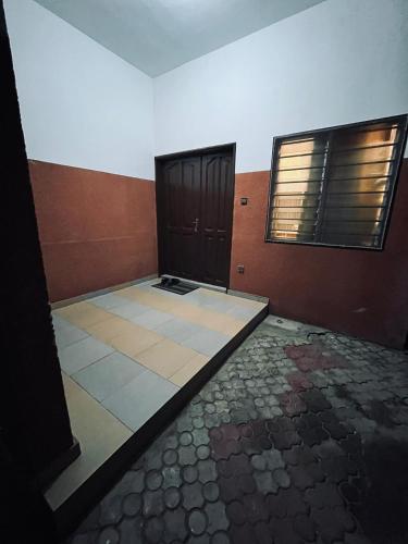 an empty room with two doors and a tiled floor at Yann Guest house in Godomè