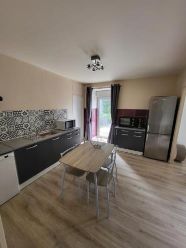 une cuisine avec une table en bois et une salle à manger dans l'établissement Chambre - Endroit paisible, à Romagné