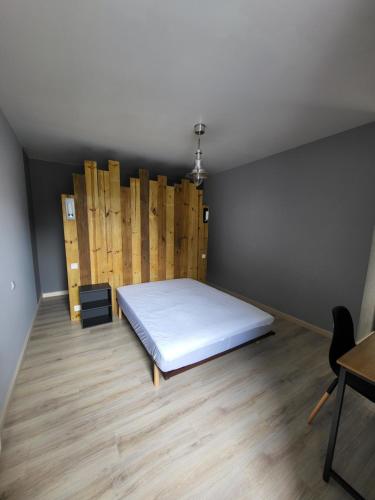 une chambre avec un lit et un parquet dans l'établissement Chambre - Endroit paisible, à Romagné