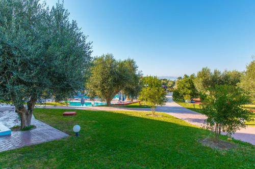 a park with green grass and trees and a path at Filoxenia Apartments & Studios in Theologos