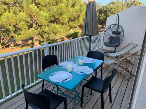 une table bleue et des chaises sur un balcon dans l'établissement Appartement en résidence privée, à Le Ranch