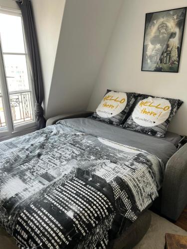 une chambre avec un lit avec une couette noire et blanche dans l'établissement Studio proche Paris - Saint Ouen - 2 PAX, à Saint-Ouen