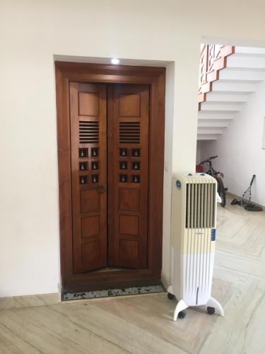 a wooden door with a radiator in front of it at Kannur Beachdrive Homestay in Thottada