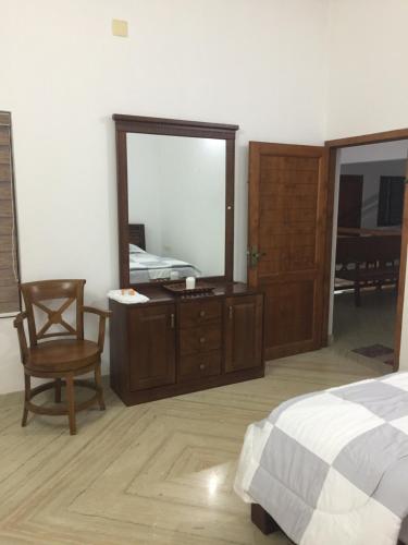 a bedroom with a mirror and a bed and a chair at Kannur Beachdrive Homestay in Thottada