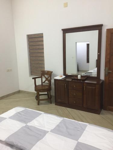 a bedroom with a large mirror and a wooden dresser at Kannur Beachdrive Homestay in Thottada